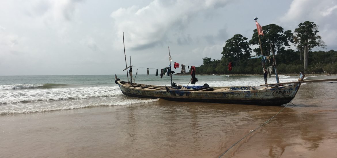 A traditional fishing boat lies beached in Busua, Western coast of Ghana