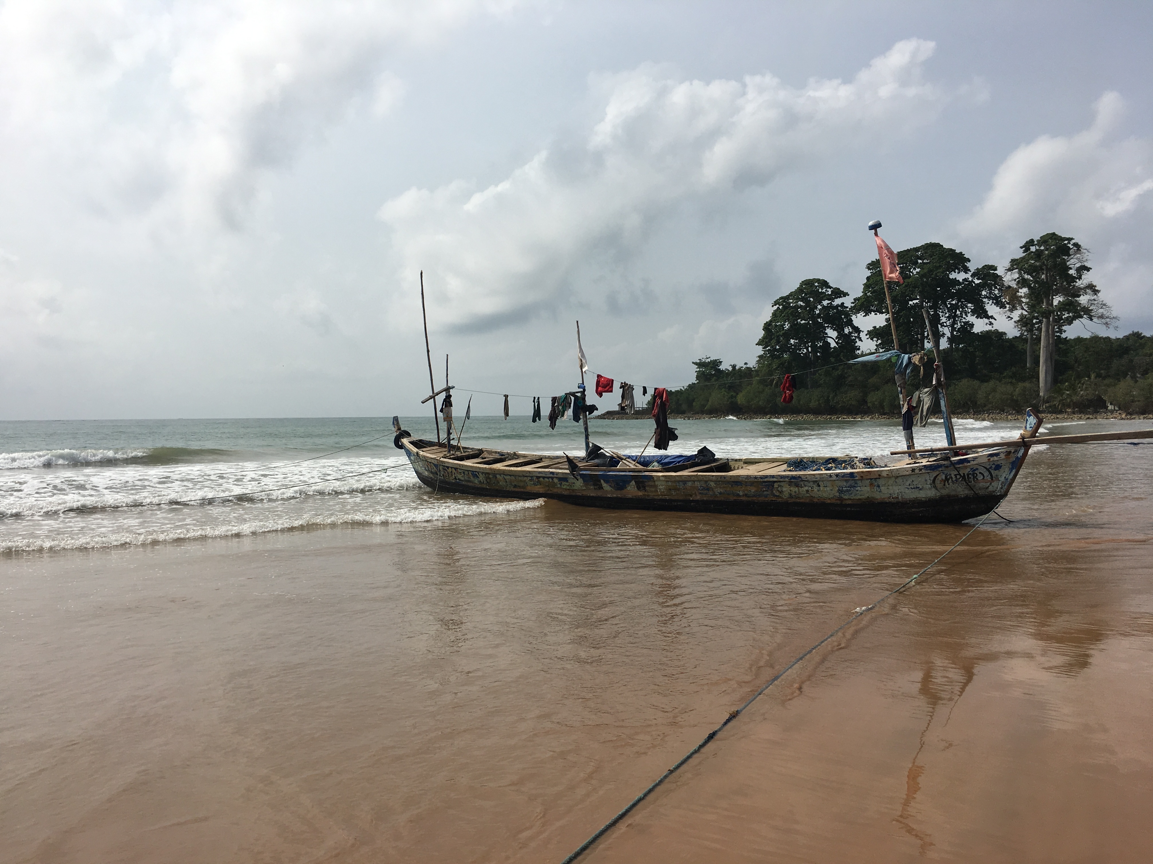 A traditional fishing boat lies beached in Busua, Western coast of Ghana